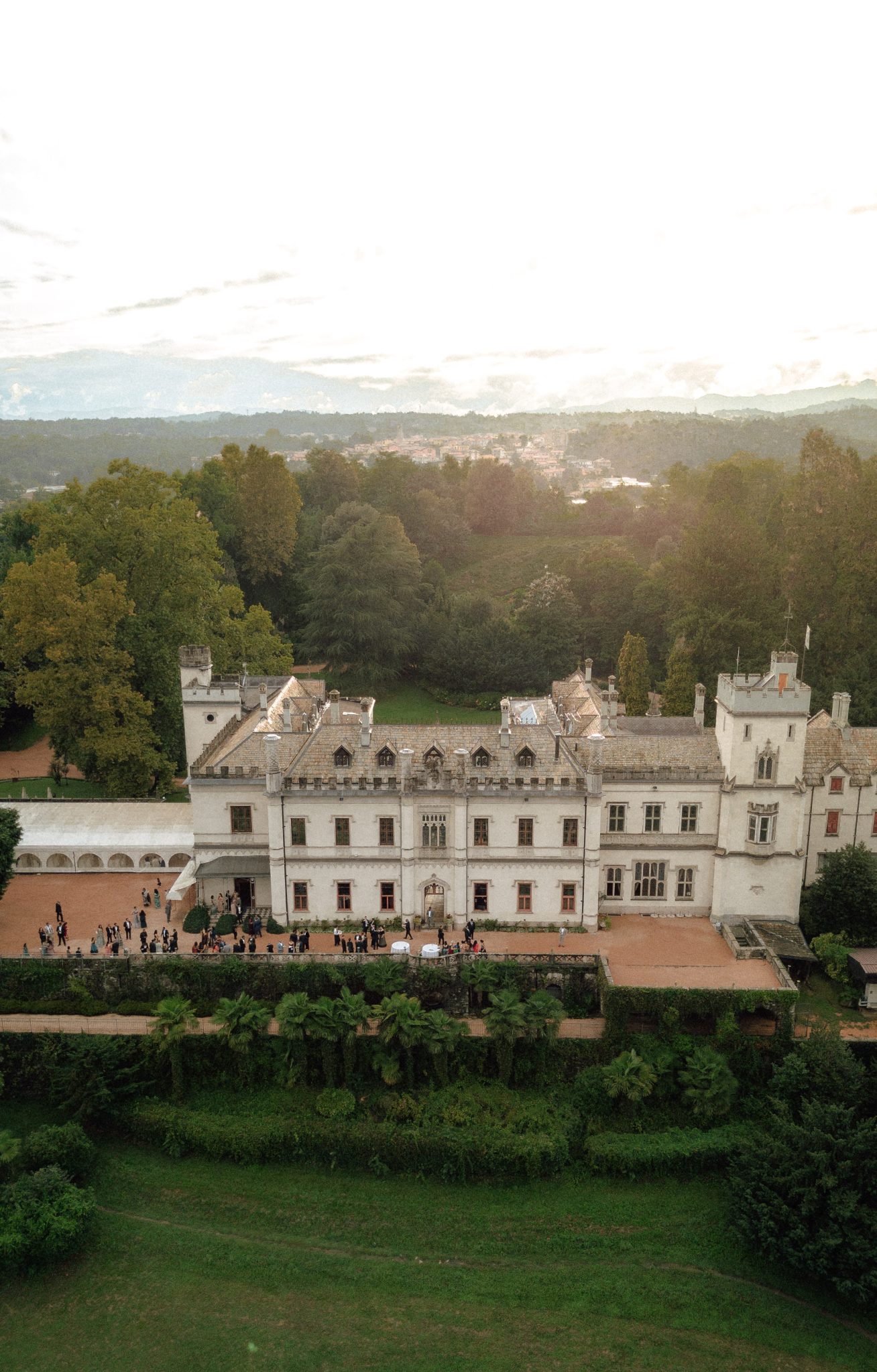 Aerial view of Castello Dal Pozzo with its park and the lake in evening light