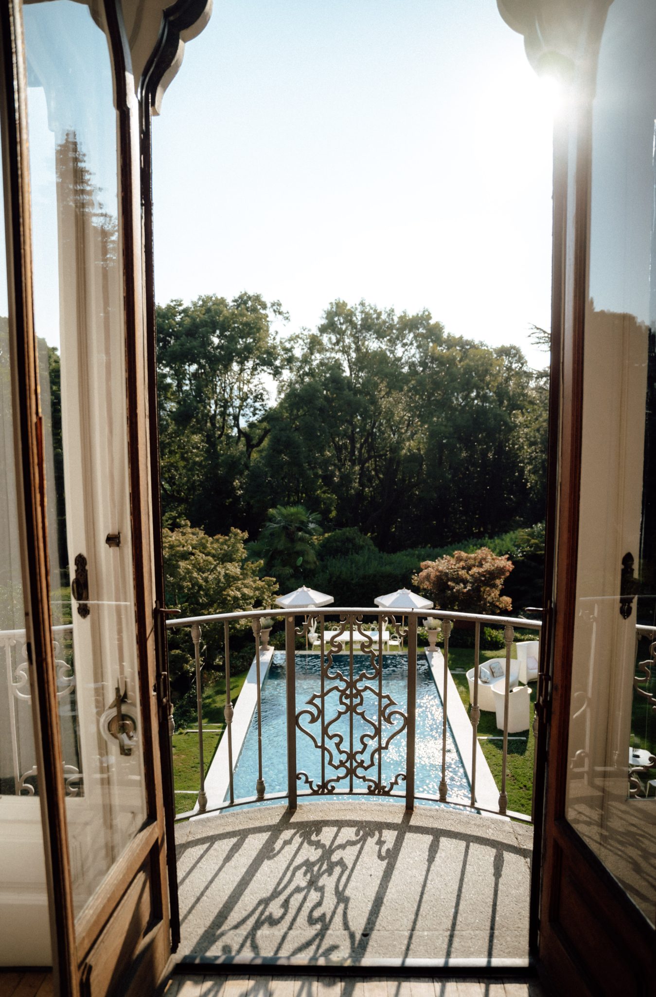 View from a balcony door over the garden pool and trees