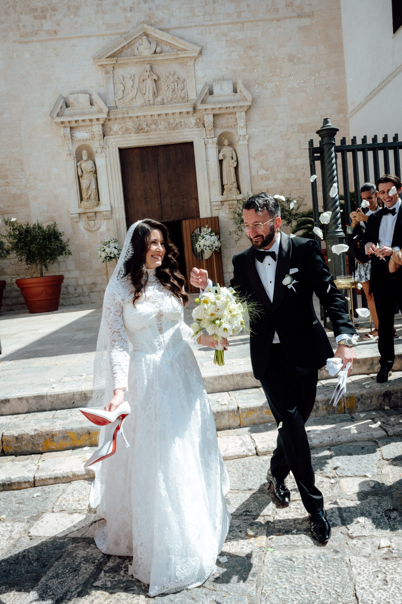 Bride and groom walking down the church steps in Polignano a Mare