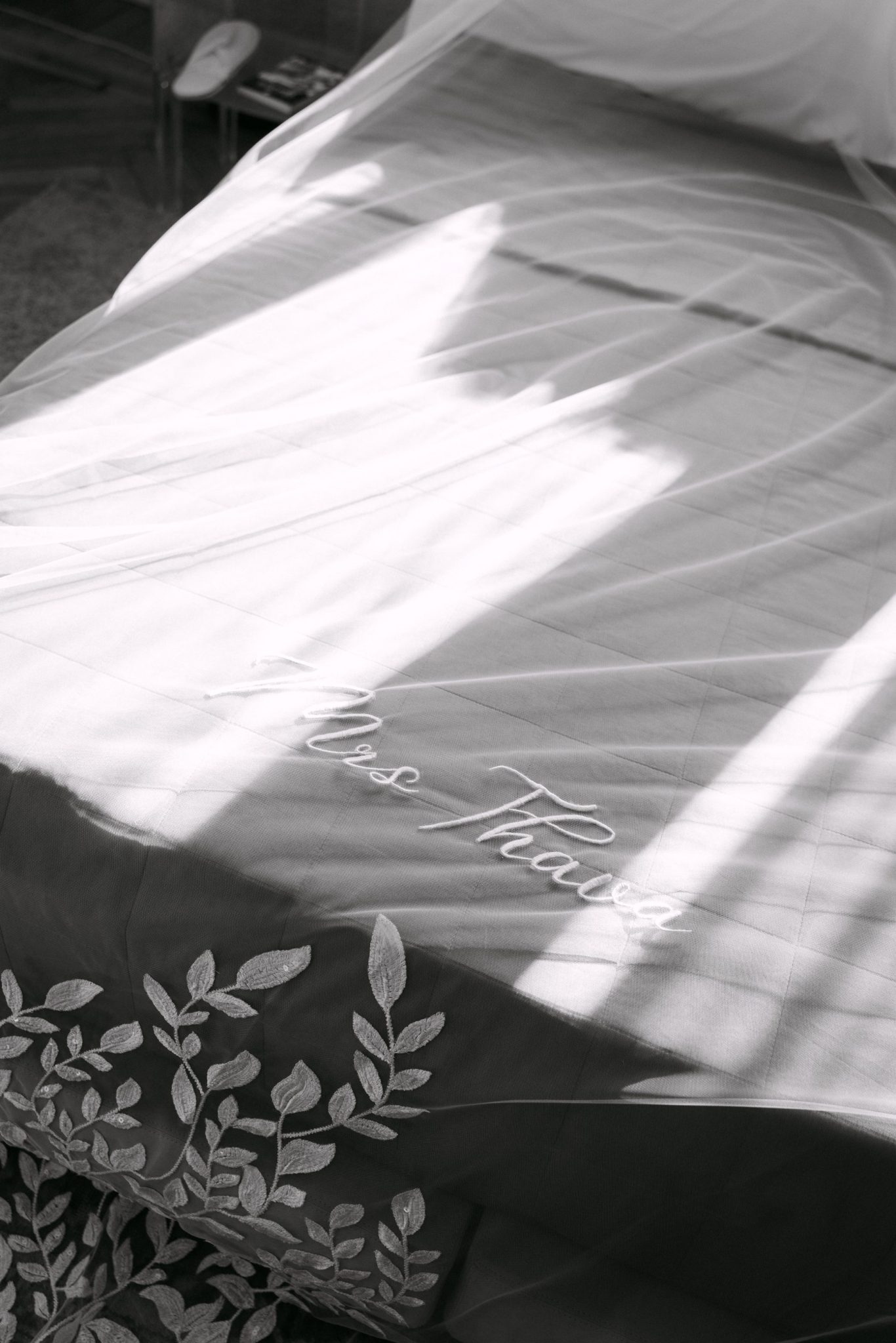 Detail of an embroidered wedding veil with a name stitched in script, black and white