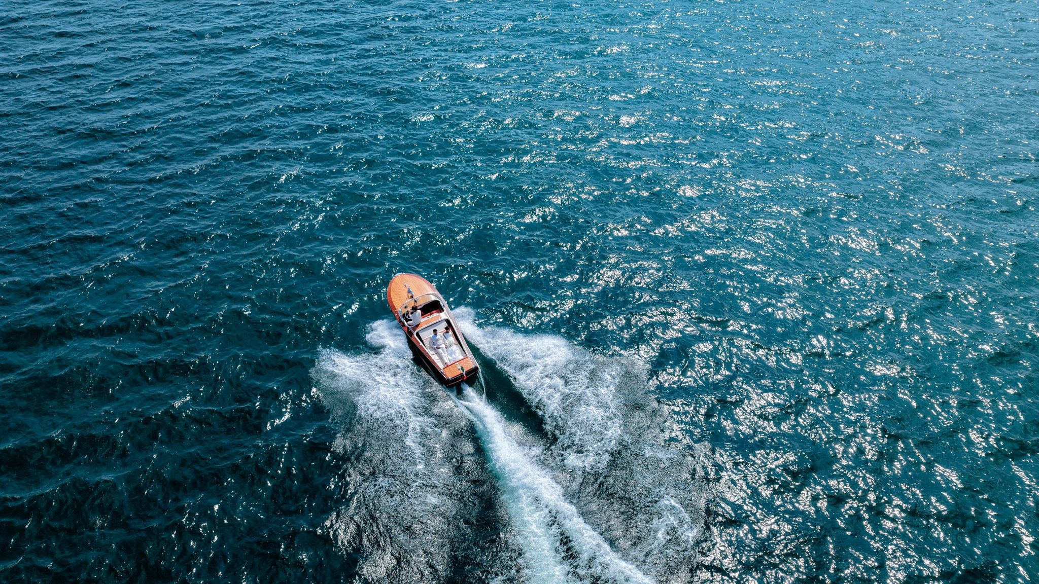 Aerial view of a classic wooden speedboat crossing Lago Maggiore