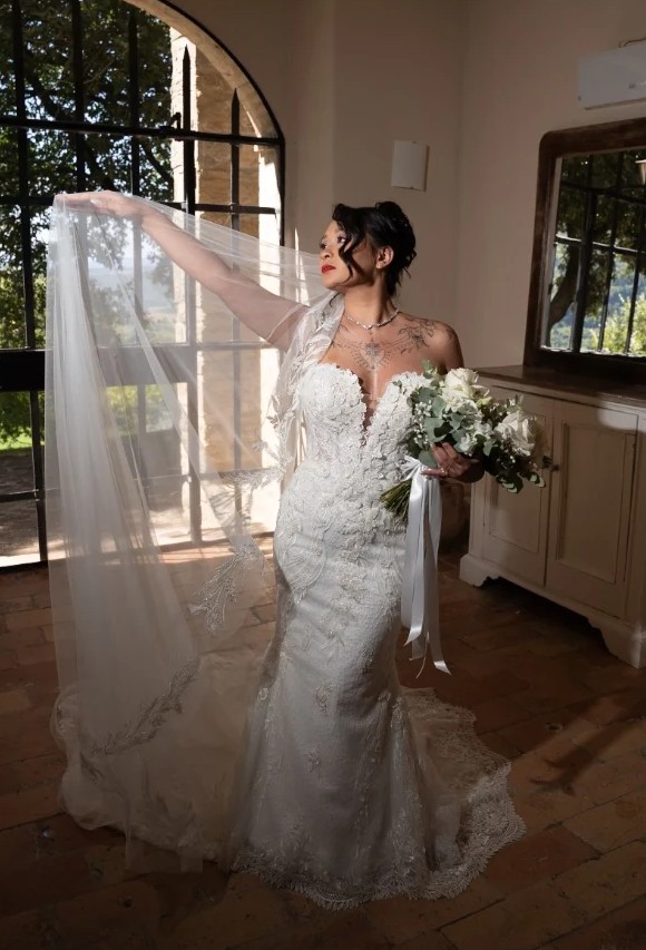 Bride with a long veil in a sunlit room, before editing