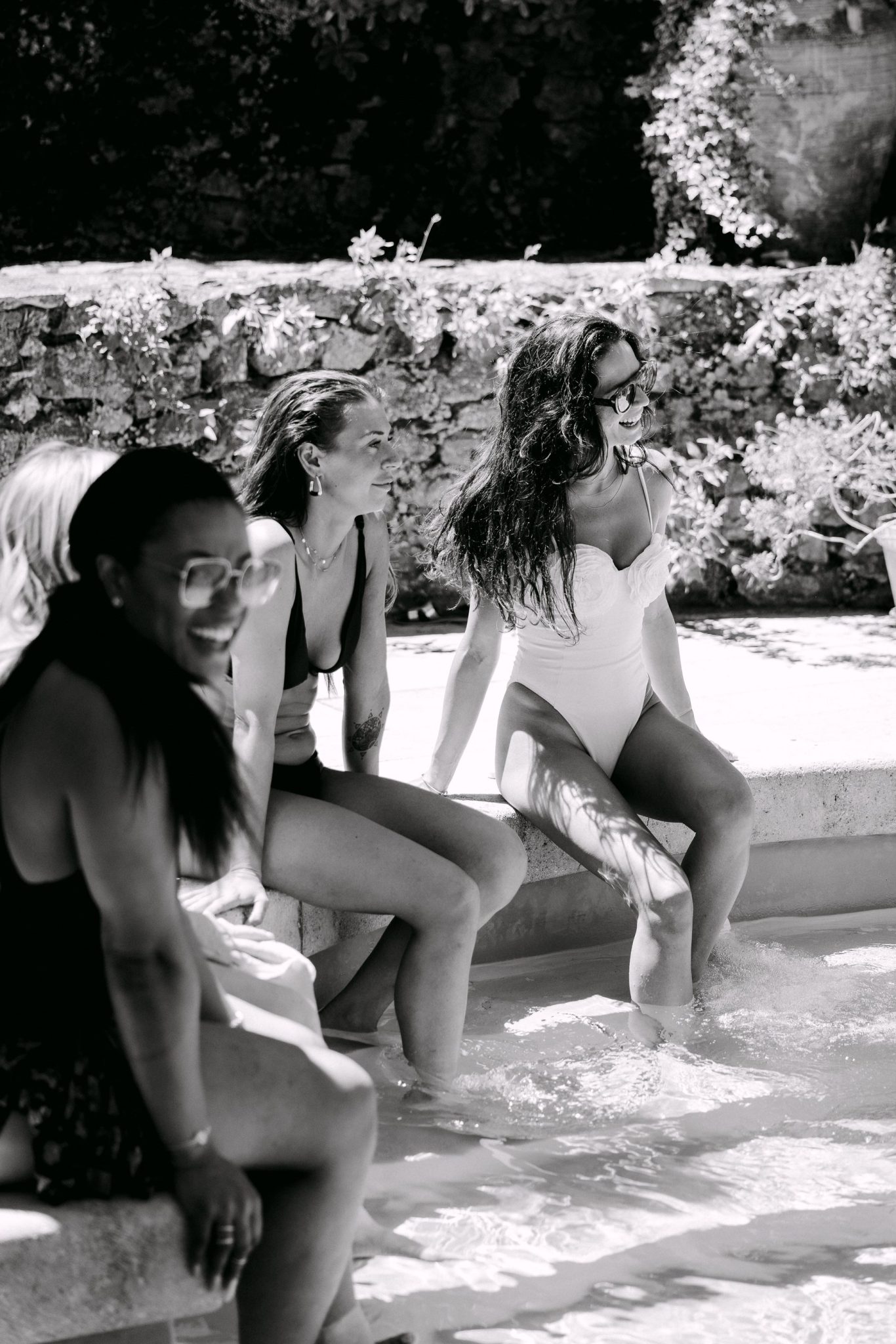 Friends sitting with their feet in a fountain, black and white