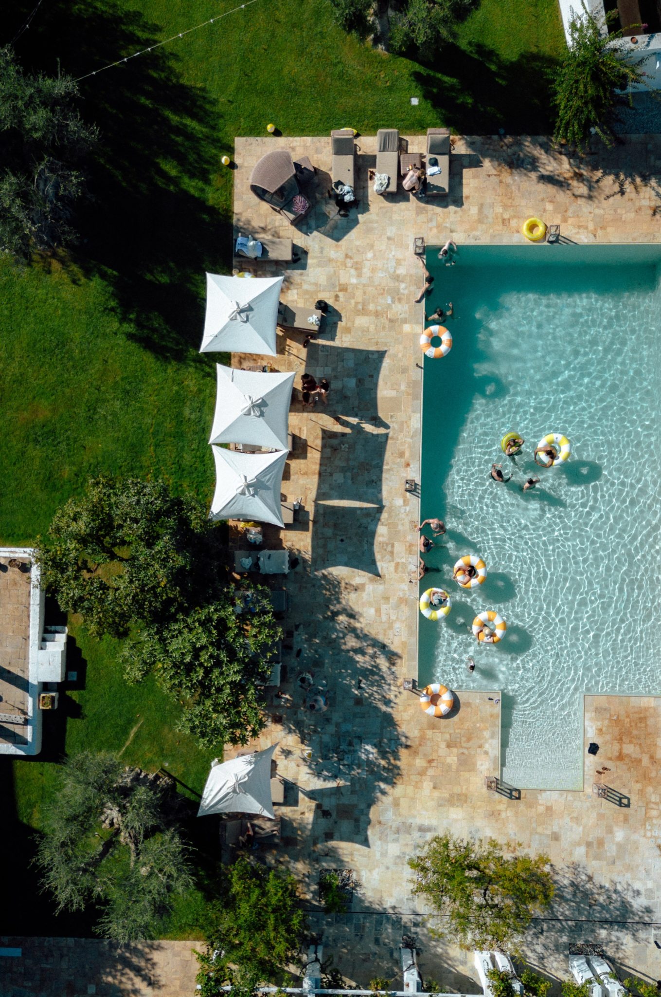 Aerial view of the pool with sun umbrellas and guests at La Masseria Lamacerase