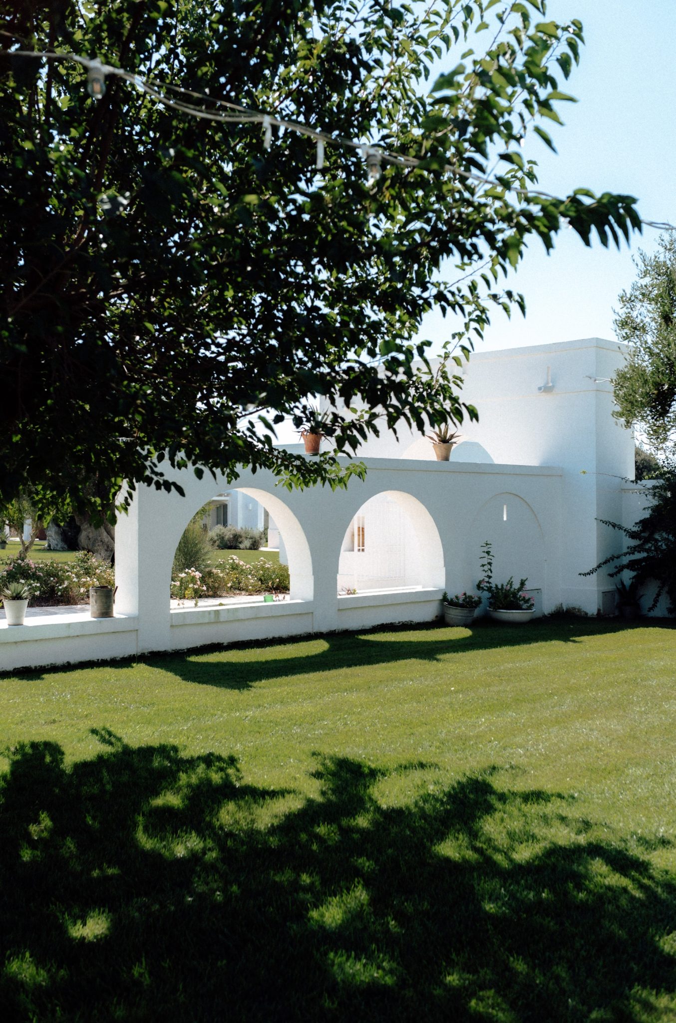 White arched garden wall and lawn at La Masseria Lamacerase in Puglia